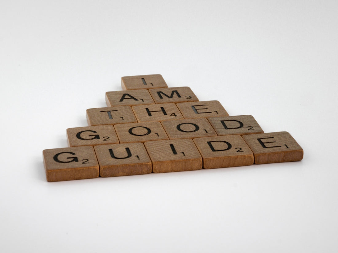 a wooden scrabble with words that read i am the good guide