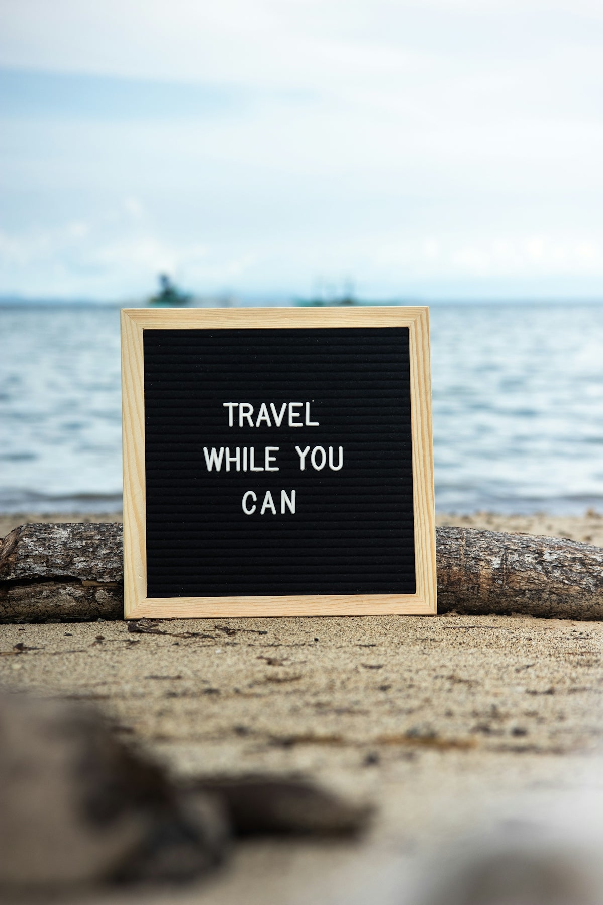 a sign that says travel while you can