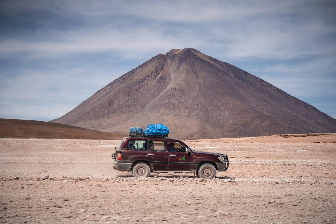a truck with a blue bag on top of it in the desert